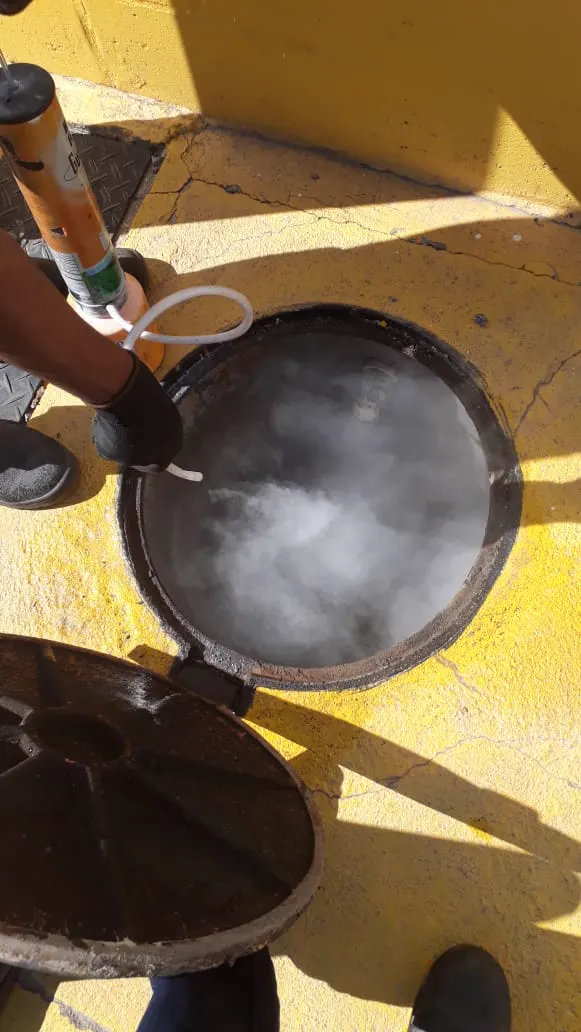 Técnico da Ambiental fazendo fumigação em bueiro